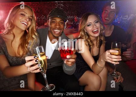 Next rounds on us. A group of friends enjoying drinks and partying in the club. Stock Photo