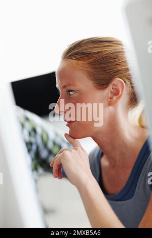 Curious about her progress. Two colleagues working on a computer together. Stock Photo