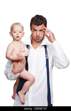 Balancing work and life. A businessman holding his son after a long day at work. Stock Photo