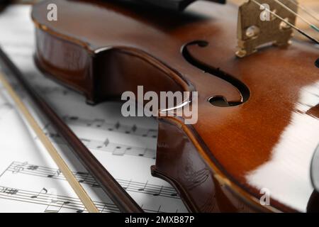 Beautiful violin, bow and note sheets, closeup Stock Photo