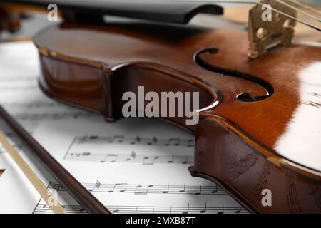 Beautiful violin, bow and note sheets, closeup Stock Photo