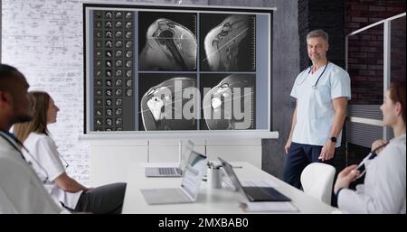 Physician Doctors Looking At Shoulder MRT Scan Stock Photo