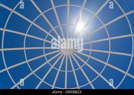 View on metal gazebo above blue sky on sunny summer day, close up Stock Photo