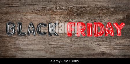 Phrase BLACK FRIDAY made of foil balloon letters on wooden background. Banner design Stock Photo