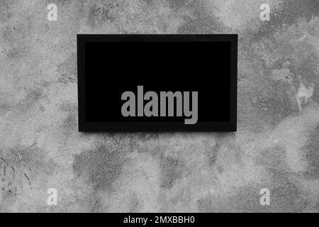 Modern TV on grey wall. Space for design Stock Photo
