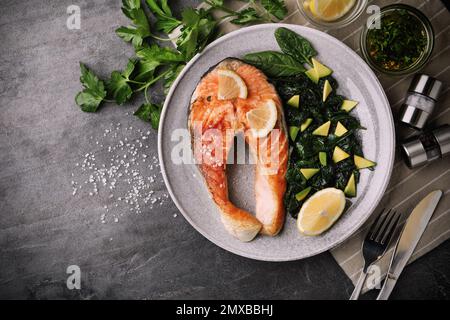 Tasty salmon with spinach served on grey table, flat lay. Food photography Stock Photo