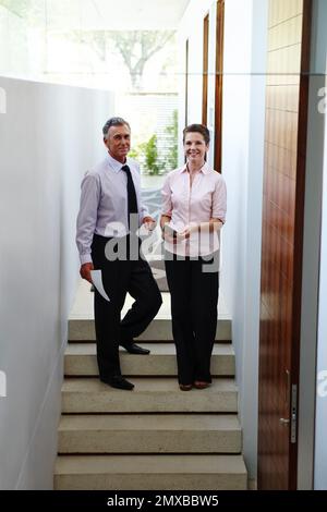 Commmunicating is an important aspect of business. Two colleagues discussing business matters in the corridor. Stock Photo