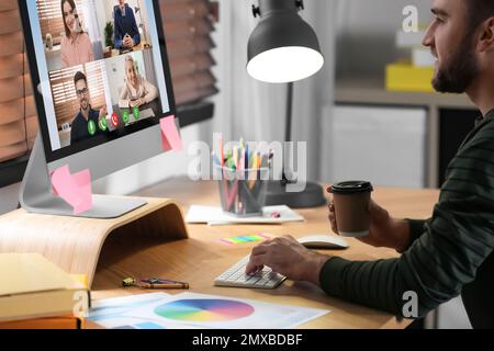 Man having video chat with colleagues at table in office. Team work Stock Photo