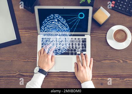 Fingerprint identification. Man working with laptop at table, top view Stock Photo