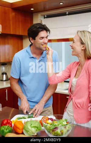 Loving moments in the kitchen. a loving married couple being playful while preparing food in the kitchen. Stock Photo