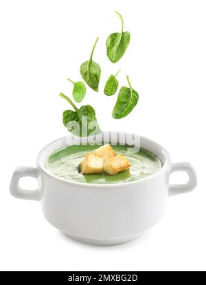 Fresh green spinach leaves falling into vegetable detox soup on white background Stock Photo