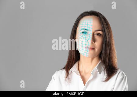 Facial recognition system. Mature woman with digital biometric grid on grey background Stock Photo
