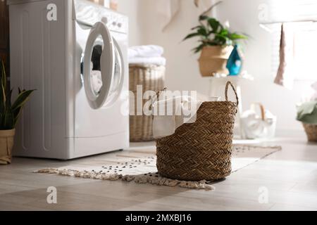 Wicker Basket With Laundry Near Washing Machine In Bathroom Stock Photo 