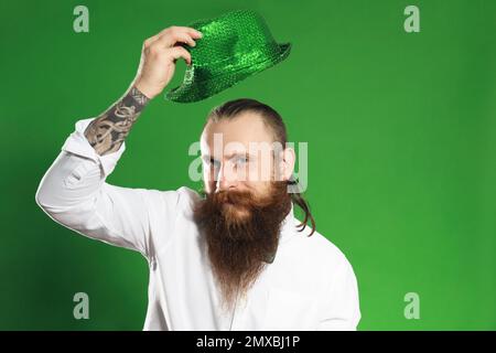 Bearded man with green hat on color background. St. Patrick's Day celebration Stock Photo