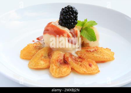 Fried bananas with ice cream,caramel sauce and blackberry Stock Photo