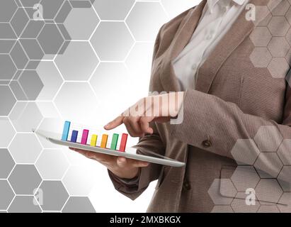 Young woman with tablet and diagram on light background, closeup. Modern technology Stock Photo