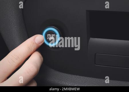 Woman pressing start button in car, closeup Stock Photo