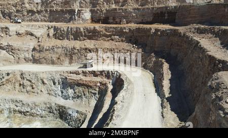 Large quarry dump truck full of stones. Transporting the ore into the crusher. Mining truck mining machinery, transport the material for production. Stock Photo