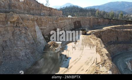 Large quarry dump truck full of stones. Transporting the ore into the crusher. Mining truck mining machinery, transport the material for production. Stock Photo