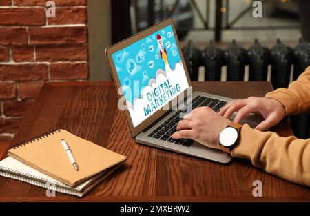 Digital marketing concept. Man working with laptop in cafe, closeup Stock Photo