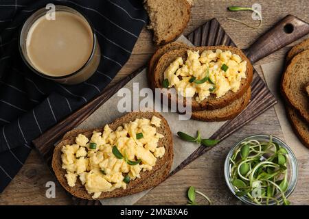 Tasty scrambled egg sandwiches served on wooden table, flat lay Stock Photo