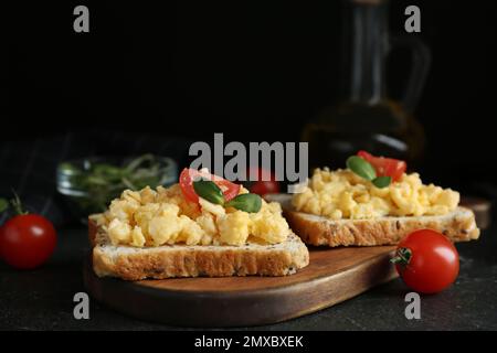 Tasty scrambled egg sandwiches served on wooden board Stock Photo