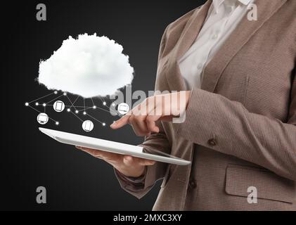 Cloud computing and storage concept. Woman using tablet on black background, closeup Stock Photo