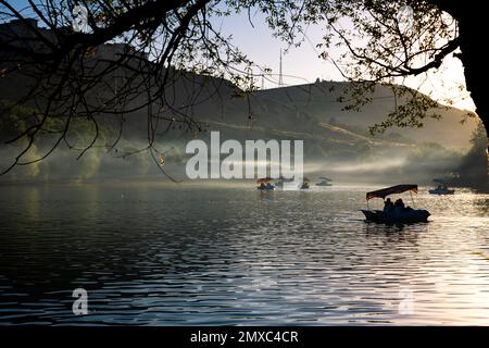 Paddleboats on the lake with haze in the forest at sunset. Leisure time activities concept photo. Selective focus. Stock Photo