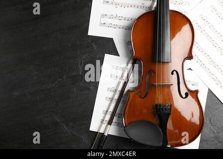 Violin, bow and note sheets on wooden table, flat lay. Space for text Stock Photo