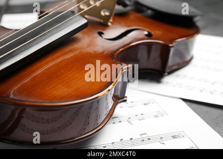 Beautiful violin and note sheets on table, closeup Stock Photo