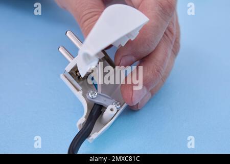 Installation of sectional European electric plug on an electrical cord. Stock Photo