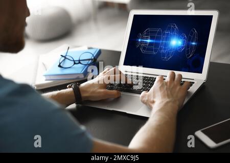Male engineer working with 3d model of modern equipment on laptop indoors, closeup Stock Photo