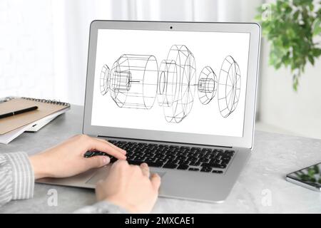 Female engineer working with 3d model of modern equipment on laptop indoors, closeup Stock Photo