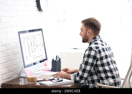 Male engineer working with technical drawing on computer indoors Stock Photo