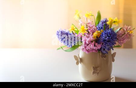 Fresh beautiful spring flowers in vase on  table. Easter decoration for home. Stock Photo