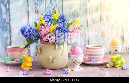 Easter breakfast table with tea,eggs in egg cups, spring flowers in vase and Easter decor Stock Photo