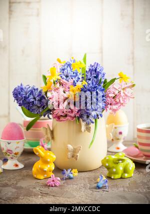 Easter breakfast table with tea,eggs in egg cups, spring flowers in vase and Easter decor Stock Photo