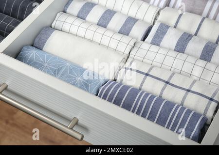 Open drawer with folded towels, closeup. Order in kitchen Stock Photo