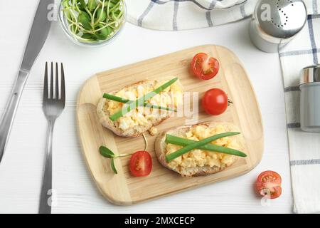 Tasty scrambled egg sandwiches served on white wooden table, flat lay Stock Photo
