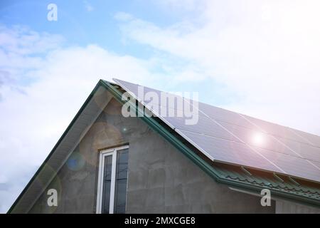 Closeup view of building with installed solar panels on roof. Alternative energy source Stock Photo