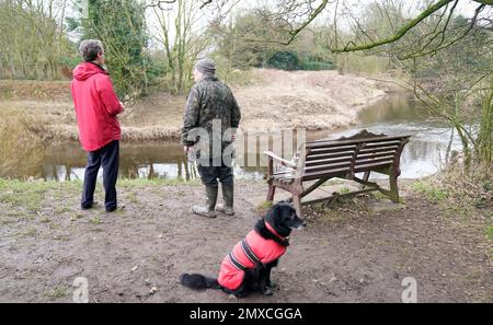 People stand beside the bench where Nicola Bulley's phone was found, on the banks of the River Wyre, in St Michael's on Wyre, Lancashire, as police continue their search for missing the woman, who was last seen on the morning of Friday January 27, when she was spotted walking her dog on a footpath by the nearby River Wyre. Picture date: Friday February 3, 2023. Stock Photo