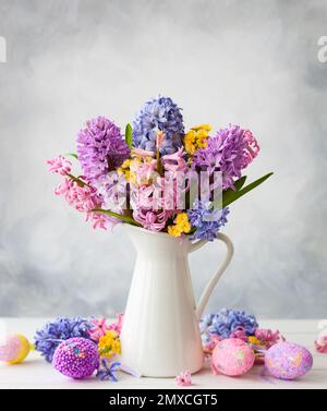 Easter still life  with lilac and pink hyacinths and Easter eggs on white table Stock Photo