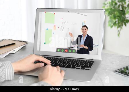 Woman using laptop for online studying at home, closeup Stock Photo