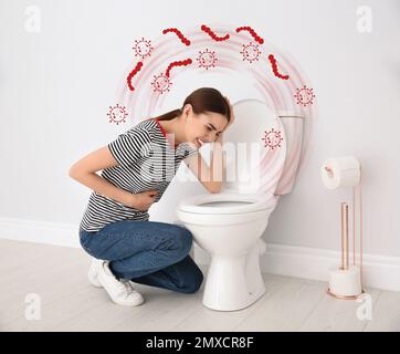 Young woman suffering from nausea at toilet bowl and bacteria illustration. Food poisoning Stock Photo