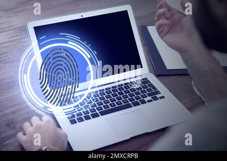 Fingerprint identification. Man working with laptop at table, closeup Stock Photo