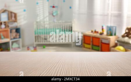 Empty wooden table in baby room interior Stock Photo - Alamy