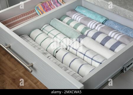 Open drawer with folded towels. Order in kitchen Stock Photo