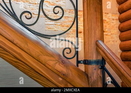 Elements of wrought iron railings and wooden stairs in a mountain chalet in the Carpathians. Stock Photo