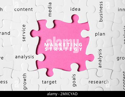 Business concept. White puzzle pieces with different phrases on pink background, top view Stock Photo