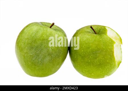apple (Malus domestica), green apple with waterdrops, one bitten Stock Photo